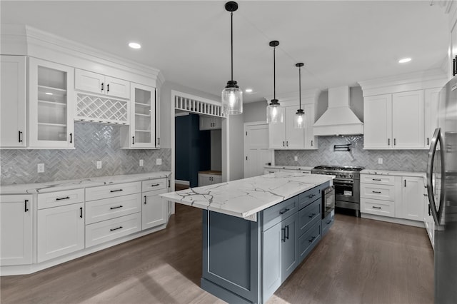 kitchen with appliances with stainless steel finishes, backsplash, dark hardwood / wood-style flooring, custom range hood, and white cabinetry