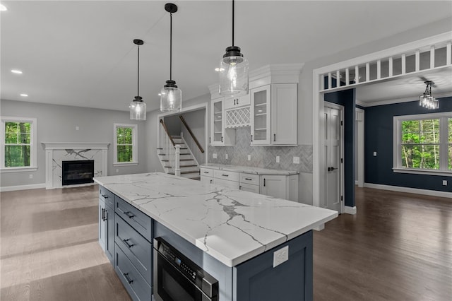 kitchen featuring white cabinets, black microwave, and a healthy amount of sunlight