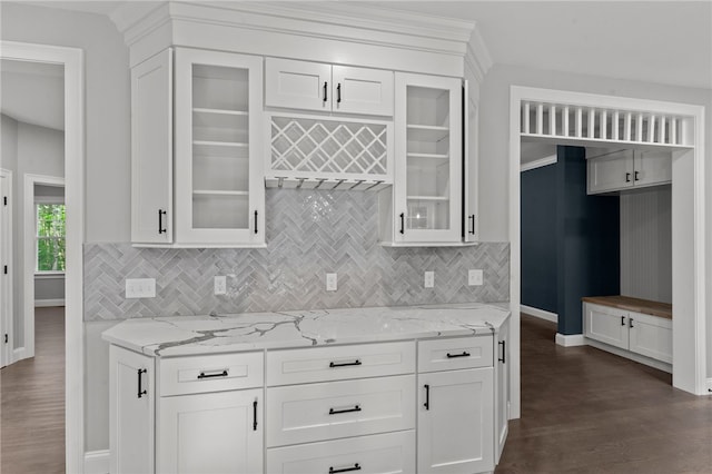 kitchen featuring backsplash, light stone countertops, white cabinetry, and dark hardwood / wood-style floors