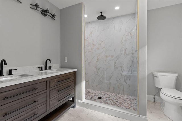 bathroom featuring vanity, toilet, and a tile shower