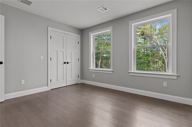 unfurnished bedroom featuring a closet and dark wood-type flooring