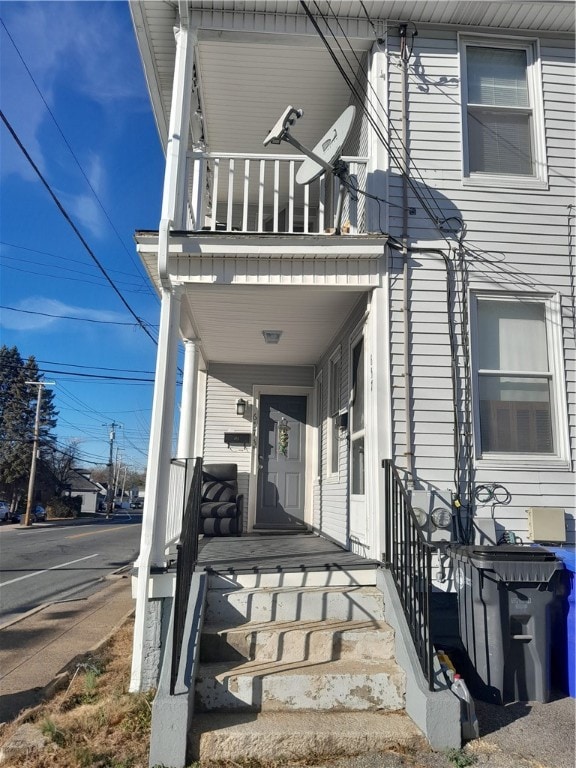 entrance to property featuring covered porch and a balcony