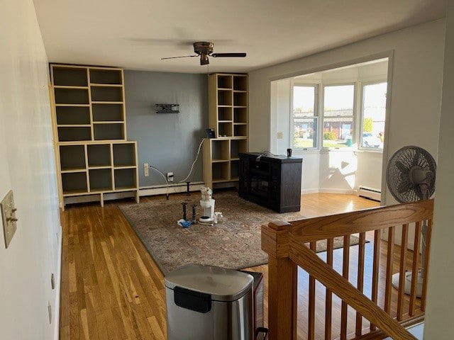 office space featuring hardwood / wood-style floors, ceiling fan, and a baseboard heating unit