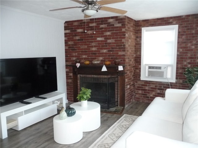 living room with a fireplace, crown molding, dark hardwood / wood-style flooring, and brick wall