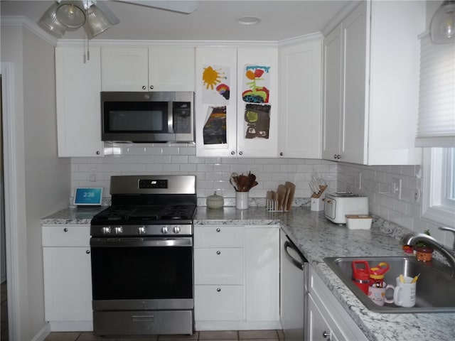 kitchen featuring white cabinets, decorative backsplash, sink, and stainless steel appliances