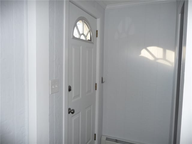 entryway with crown molding and a baseboard heating unit