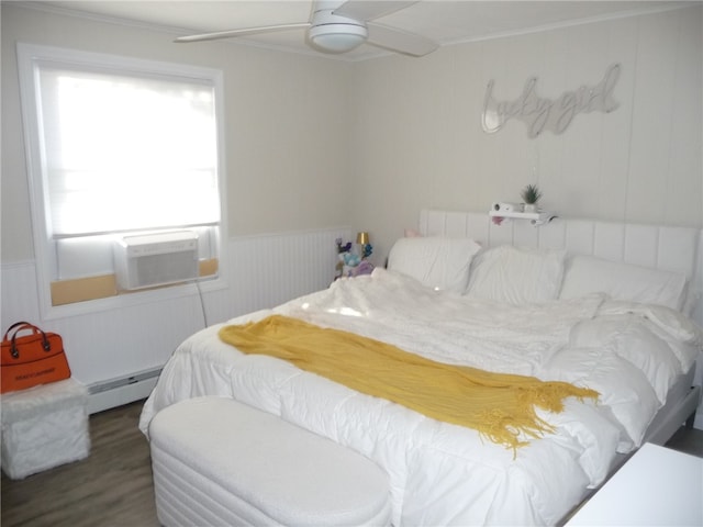 bedroom with ceiling fan, dark hardwood / wood-style flooring, crown molding, and a baseboard heating unit