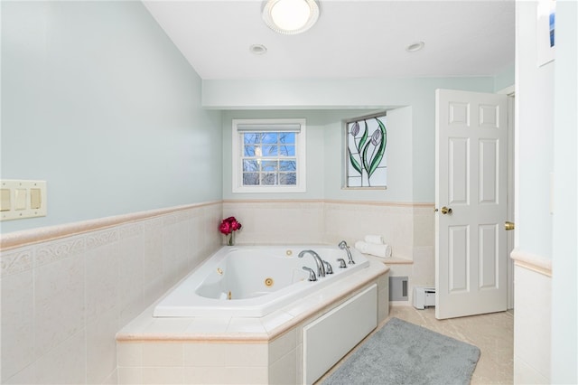 bathroom featuring baseboard heating, tile patterned flooring, and a relaxing tiled tub