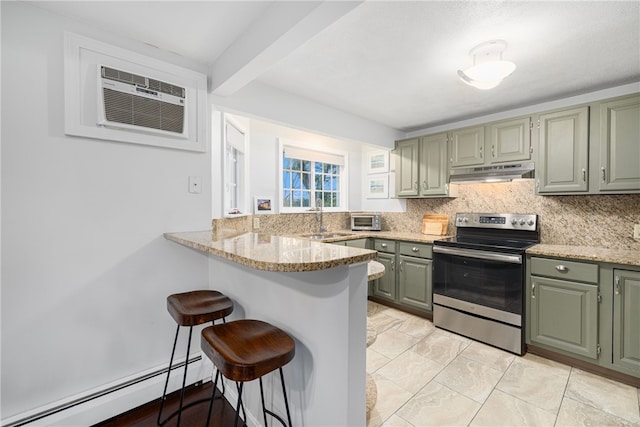 kitchen featuring a breakfast bar, stainless steel range with electric cooktop, a baseboard heating unit, decorative backsplash, and kitchen peninsula