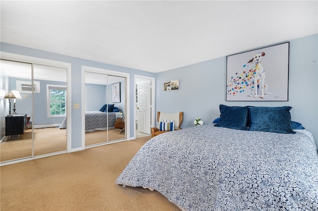 carpeted bedroom featuring a baseboard radiator, a wall unit AC, and multiple closets