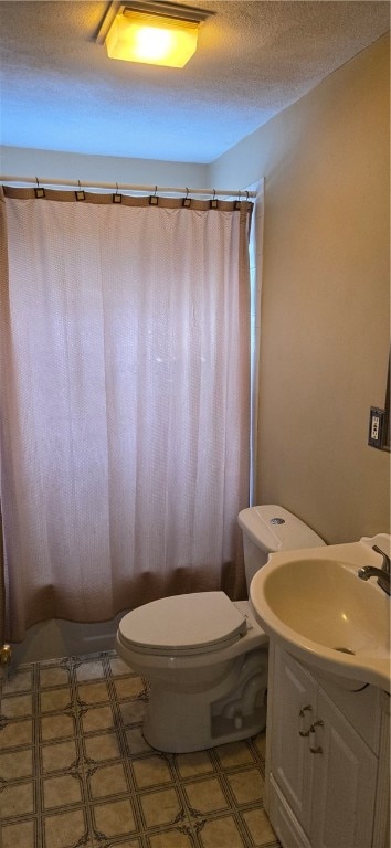 bathroom with a shower with curtain, vanity, a textured ceiling, and toilet