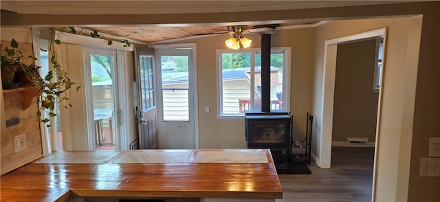 dining area with hardwood / wood-style floors, ceiling fan, a wood stove, and wooden ceiling