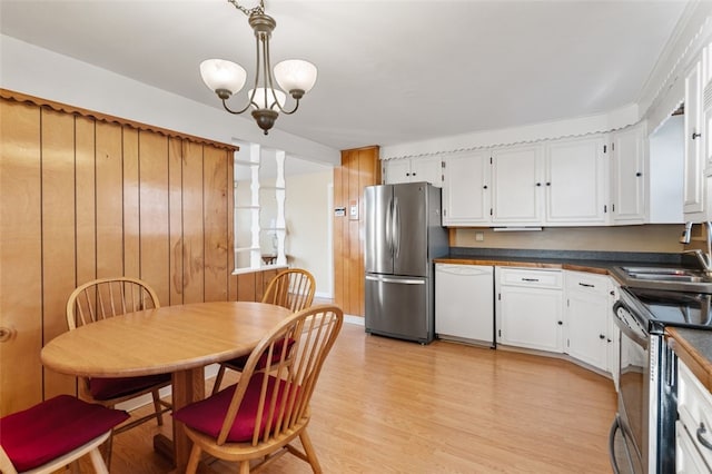 kitchen with stainless steel appliances, sink, light hardwood / wood-style flooring, a notable chandelier, and white cabinetry