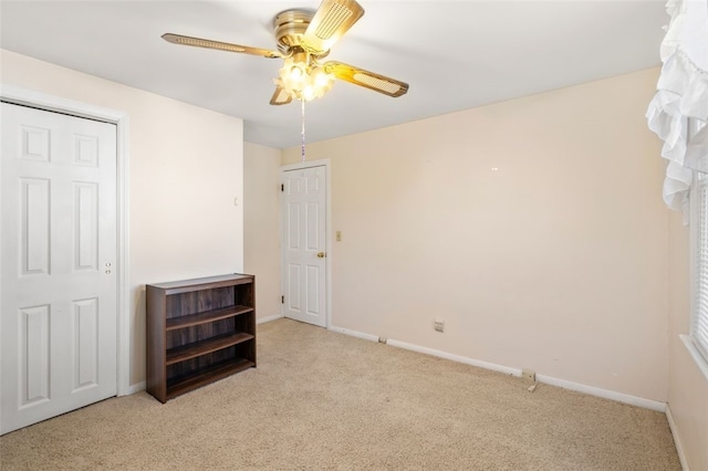 bedroom with ceiling fan, light carpet, and a closet