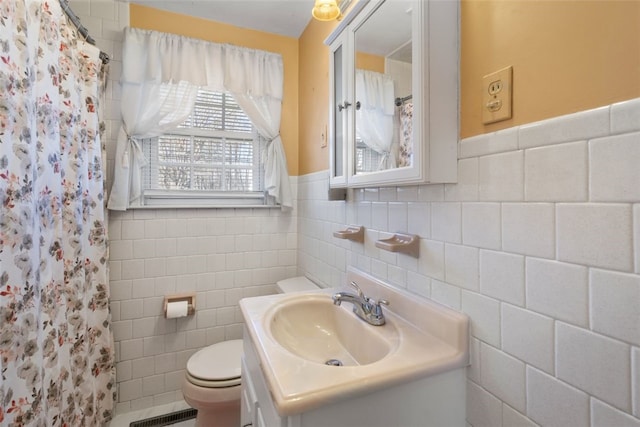 bathroom with toilet, vanity, tile walls, and walk in shower