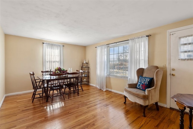 dining room with light hardwood / wood-style flooring and a healthy amount of sunlight