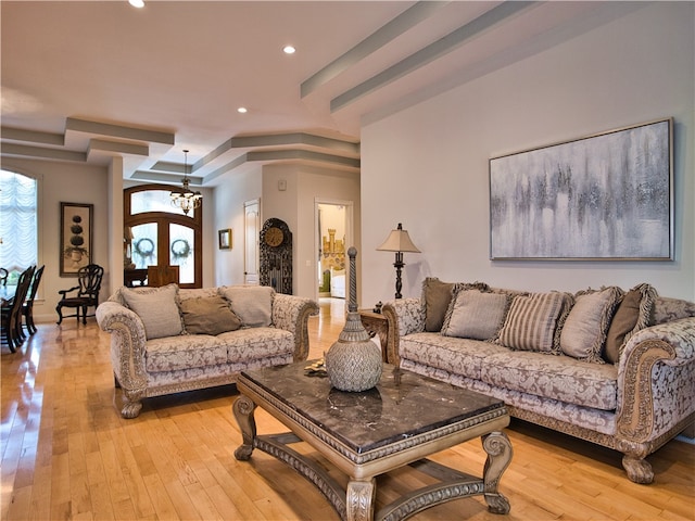 living room featuring a chandelier, french doors, and light hardwood / wood-style flooring