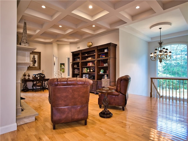 living room featuring a notable chandelier, light hardwood / wood-style floors, beam ceiling, and coffered ceiling