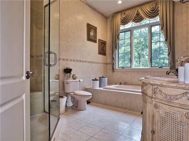 full bathroom featuring tile patterned floors, vanity, tile walls, independent shower and bath, and toilet