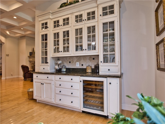 bar featuring beam ceiling, beverage cooler, coffered ceiling, and light hardwood / wood-style floors