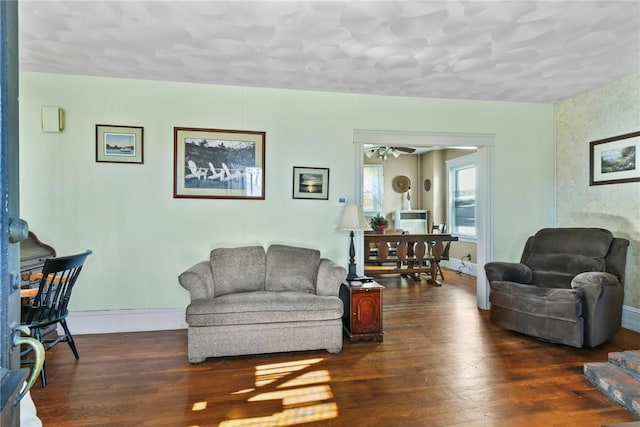 living room with ceiling fan and dark wood-type flooring