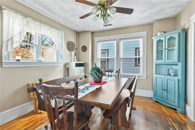 dining space featuring ceiling fan, plenty of natural light, and dark wood-type flooring