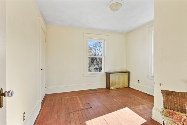 unfurnished room with wood-type flooring and radiator heating unit