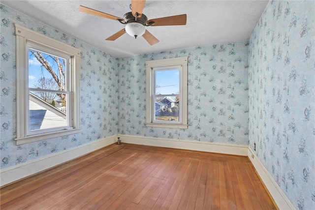 unfurnished room featuring ceiling fan, wood-type flooring, and a textured ceiling