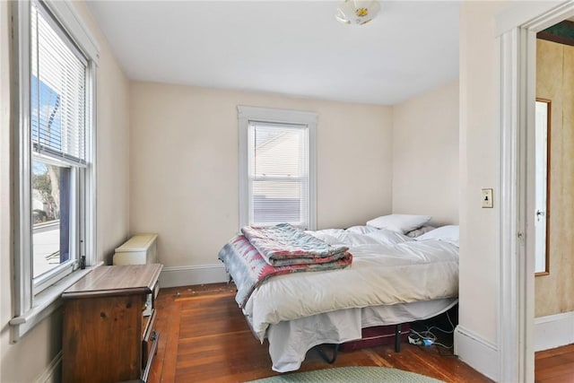 bedroom featuring dark hardwood / wood-style flooring and multiple windows