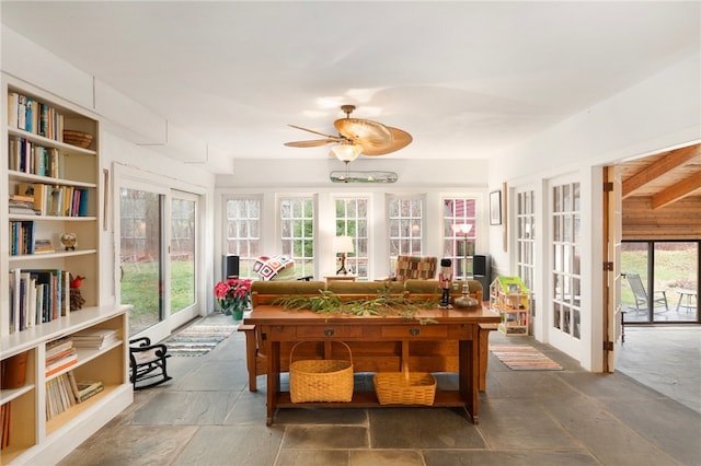 sunroom / solarium featuring ceiling fan and beamed ceiling