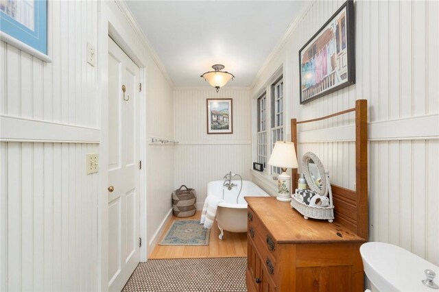 bathroom featuring hardwood / wood-style floors, a bathtub, and crown molding