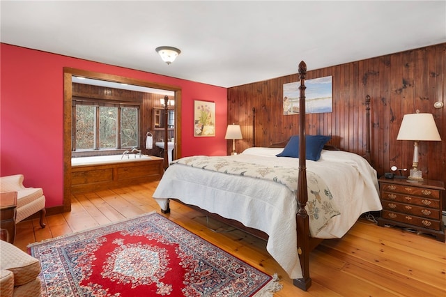 bedroom featuring hardwood / wood-style floors and wooden walls