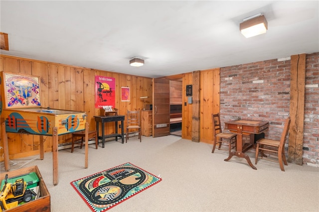 recreation room featuring carpet, brick wall, baseboard heating, and wooden walls