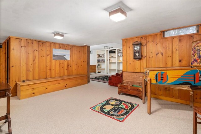 bedroom with wooden walls and light colored carpet