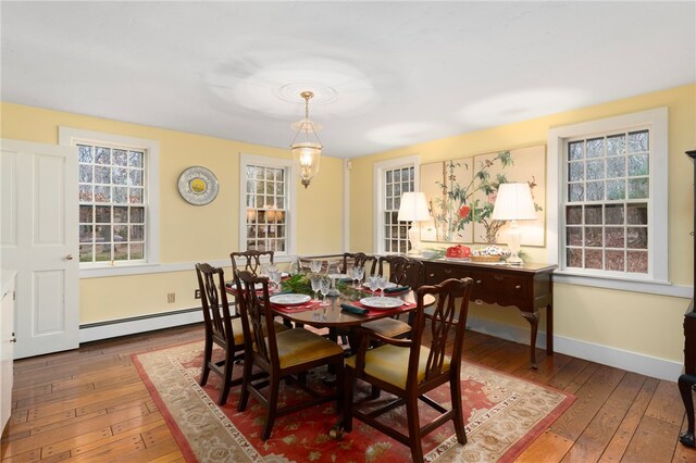 dining space featuring baseboard heating and wood-type flooring