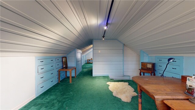 bonus room featuring dark colored carpet, wooden walls, and lofted ceiling