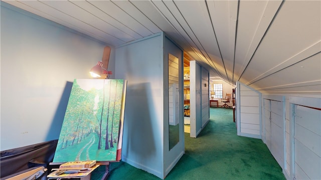 hallway with dark colored carpet and lofted ceiling