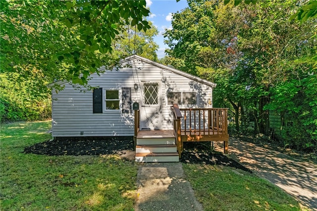 bungalow with a wooden deck and a front lawn