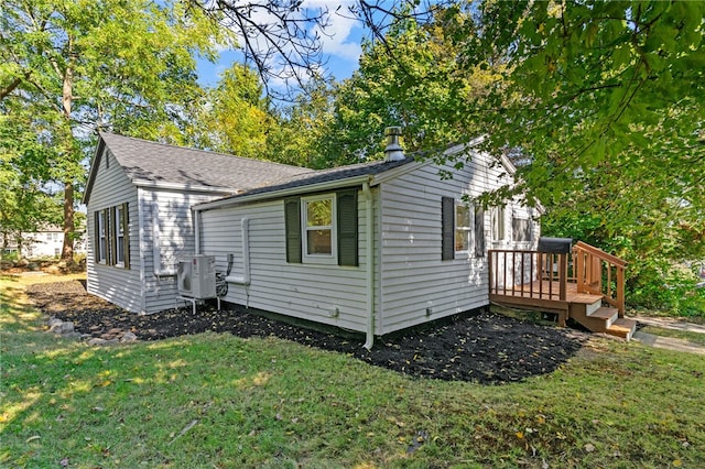 view of side of home with ac unit and a lawn