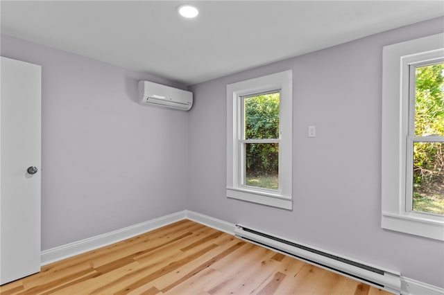 spare room with hardwood / wood-style floors, a healthy amount of sunlight, and a baseboard radiator