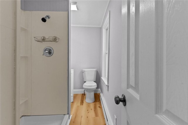 bathroom featuring hardwood / wood-style floors, a baseboard radiator, toilet, and walk in shower