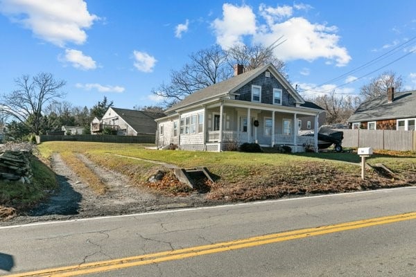 view of front of property with covered porch and a front yard