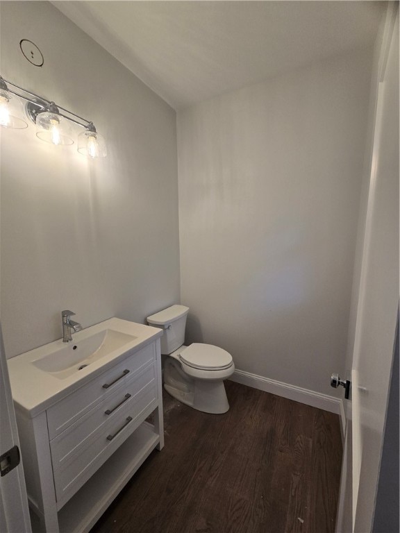 bathroom with hardwood / wood-style floors, vanity, and toilet