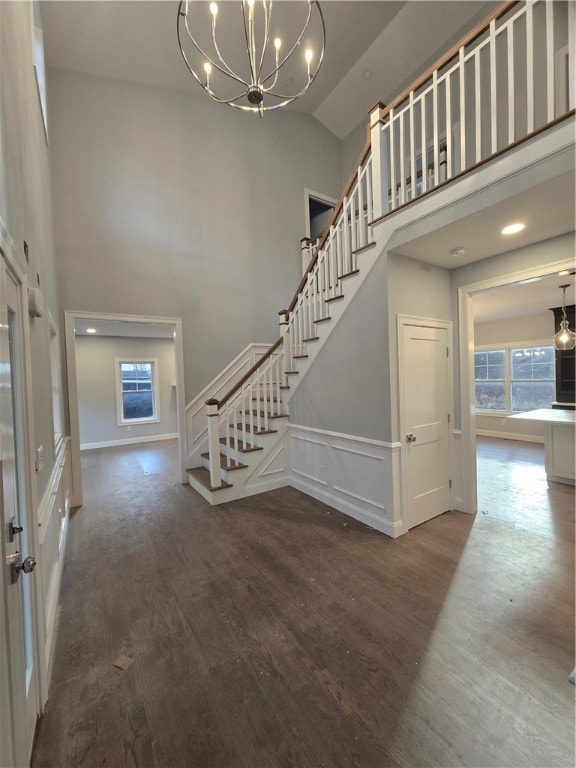 foyer with hardwood / wood-style flooring, high vaulted ceiling, and a notable chandelier