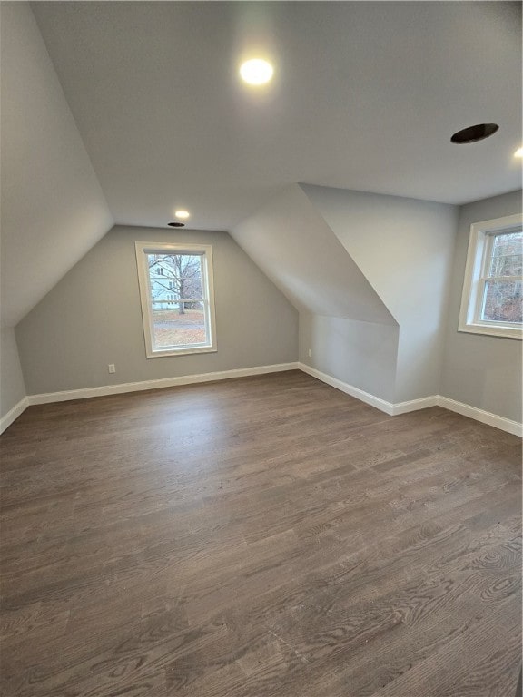 bonus room with dark hardwood / wood-style flooring and vaulted ceiling