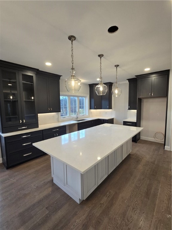 kitchen with a center island, hanging light fixtures, dark hardwood / wood-style floors, and sink