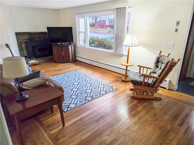 living room featuring light hardwood / wood-style flooring and a baseboard heating unit