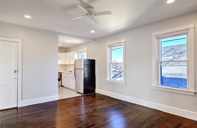 interior space featuring plenty of natural light, white cabinets, stainless steel appliances, and hardwood / wood-style flooring