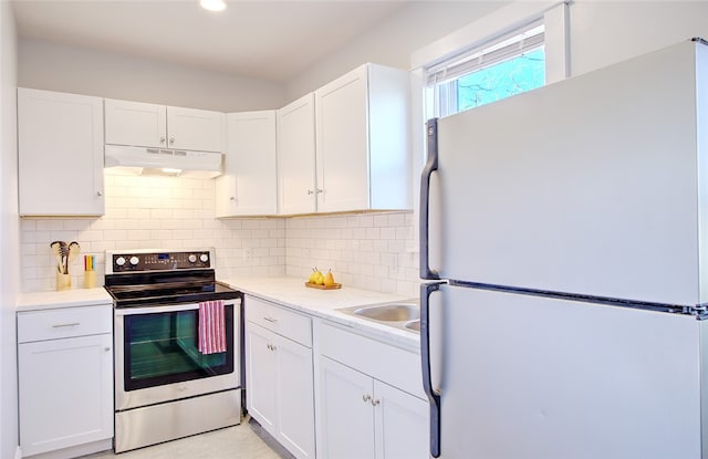 kitchen featuring white refrigerator, white cabinetry, and stainless steel electric range