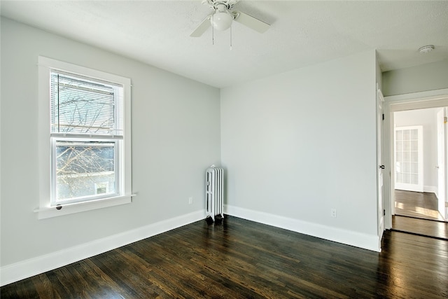 unfurnished room with ceiling fan, dark hardwood / wood-style flooring, radiator heating unit, and a textured ceiling